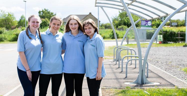 Four young girls stood outside a bike shed